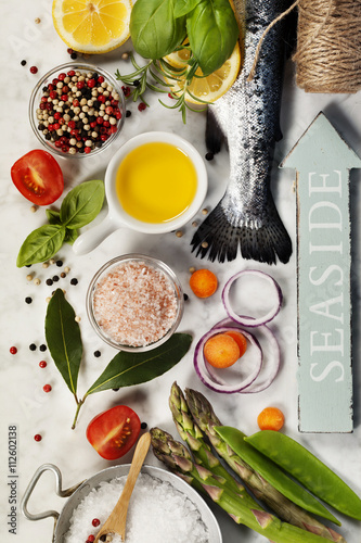 Fotografering Raw rainbow trout with vegetables, herbs and spices