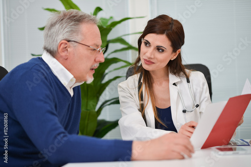 Fotografia, Obraz Doctor speaking to her patient while showing some documents