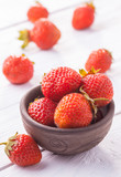Fototapeta Miasta - Fresh red strawberries with cream on the white wooden table.