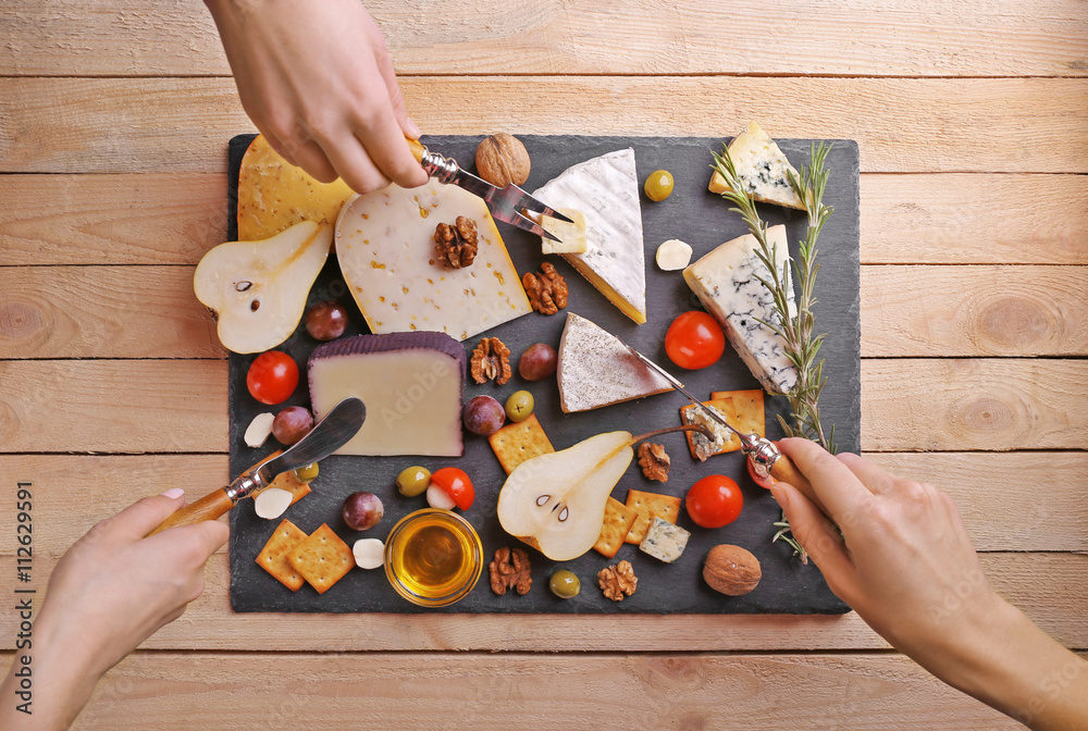 Different kinds of cheese on wooden background
