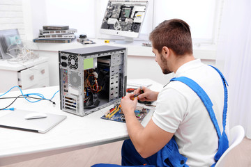 Young repairer working with screwdriver in service center