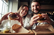 © ArtFamily - A woman and a man are enjoying their burgers