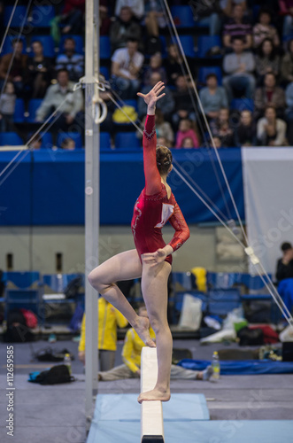 Fotografia Gymnastics. Gymnast doing a exercise on the Balance Beam.