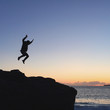 © heidilee - Silhouette of a person jumping on a big rock on a beach