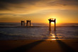 © Karen Hutton - Silhouette of dilapidated pier supports in ocean at sunset