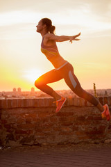 Wall Mural - jumping girl silhouette in sunset