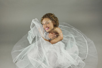 Wall Mural - High angle beautiful young ballerina sit in the floor with a whi