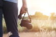 © ipopba - woman holding camera in hand on sunset nature background