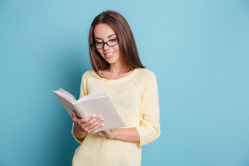 Sticker - Young girl reading book over blue background