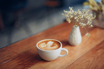 Wall Mural - cup of coffee latte art on the wooden desk