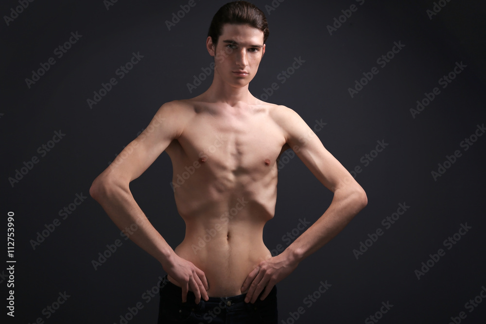 Skinny young man with anorexia on dark background