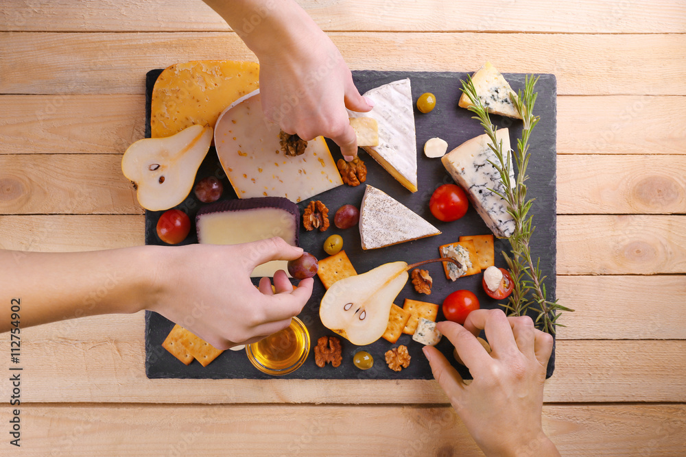 Different kinds of cheese on wooden background