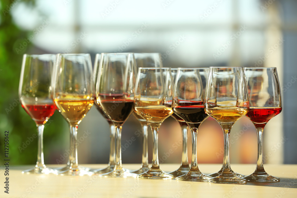 Many glasses of different wine in a row on a table