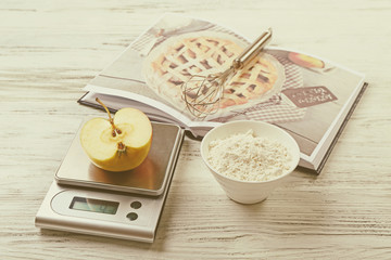 Wall Mural - Making apple pie. Using digital kitchen scales on wooden table. Cooking apple cake concept