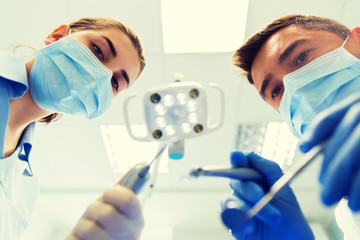 Canvas Print - close up of dentist and assistant at dental clinic