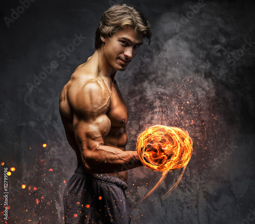 Portrait of a man with burning dumbbell. Fototapete