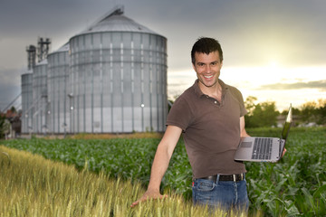 Farmer in front of grain silo