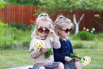 twins girls with bunches of daisies