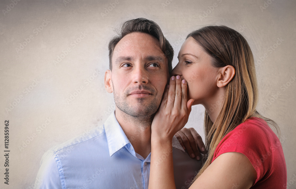 StockFoto „Woman whispering into a man's