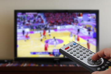 Remote control in the hand, during a basket match