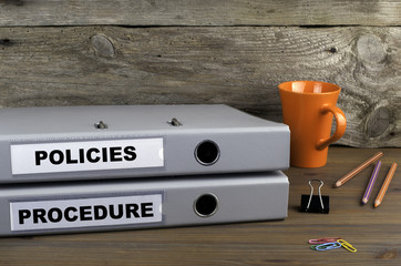 Procedure and Policies - two folders on wooden office desk