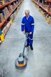 © Wavebreak Media - Man cleaning warehouse floor with machine