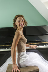 Wall Mural - Smiley ballerina performing and playing the piano in a house