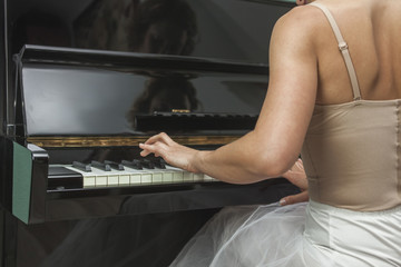 Wall Mural - Rear view ballerina performing and playing the piano in a house