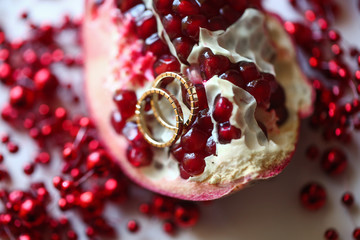 Two wedding rings on Garnet. Fruit white table