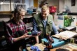 © Wavebreak Media - Cobbler showing a shoe to his colleague