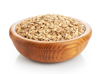 Wooden bowl with oats isolated on white background.