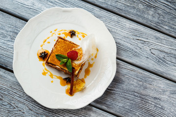 Wall Mural - Cake with mint leaf. Raspberry on piece of cake. Top view of honey cake. Cinnamon stick and honey drops.