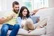 © WavebreakMediaMicro - Couple sitting on sofa and using digital tablet in living room