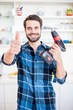 © WavebreakmediaMicro - Portrait of man showing thumbs up while holding drill machine