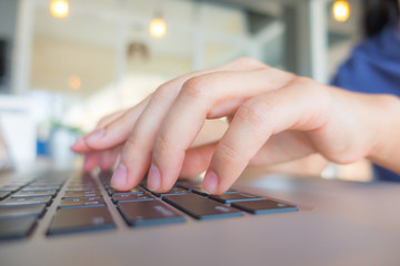 Wall Mural - Closeup of business woman hand typing on laptop keyboard with mo