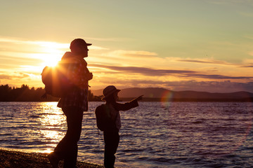 Wall Mural - father and son playing on the coast of lake in the mountains