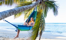 Young Woman Reclining In Palm Tree Hammock, Dominican Republic, The Caribbean