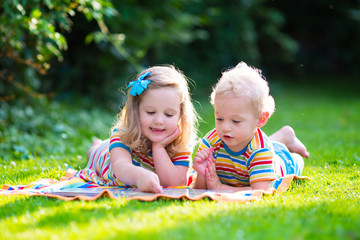 Wall Mural - Two kids reading in summer garden