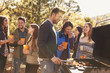 © Monkey Business - Group of friends stand at a barbecue, one cooking at grill