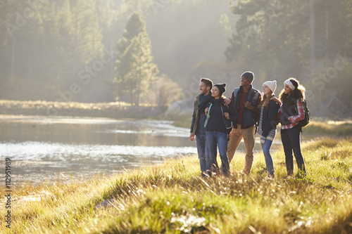 Zdjęcie: Five friends walking near a lake stop to take in the view Five friends walking near a lake stop to take in the view