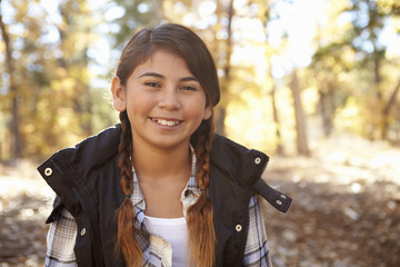 Head and shoulders portrait of a Hispanic girl in a forest