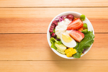 Fresh healthy salad on wooden table. View from above with copy s