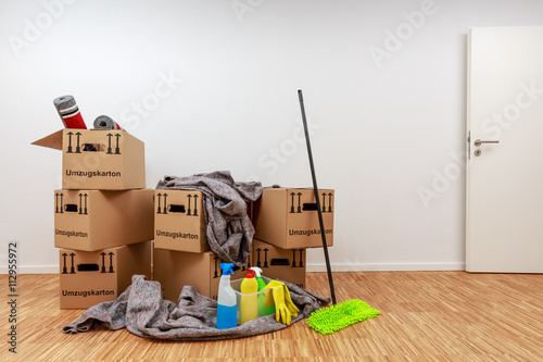Fotografía Sauberer, weißer Raum mit Kartons und Putzzeug