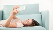 © leszekglasner - Young woman sitting on couch at home and reading ebook on tablet computer. Casual style indoor shoot