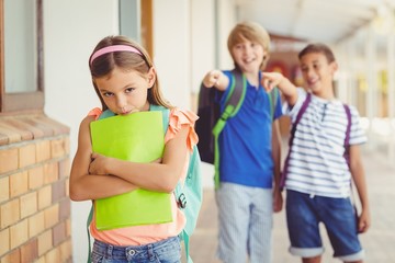 Wall Mural - School friends bullying a sad girl in corridor