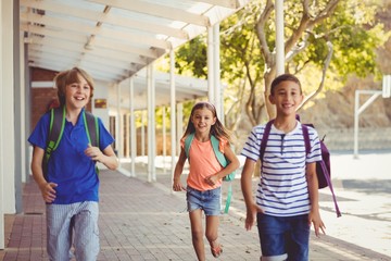 Wall Mural - Happy school kids running in corridor