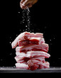 © Mittongtare - Person sprinkling salt onto pork belly