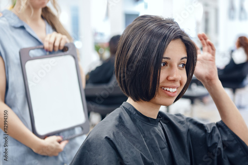 Fotomural Closeup portrait of hispanic latin girl woman sitting in chair in hair salon loo