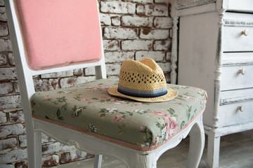 Wall Mural - Men's hat lying on the pink chair against