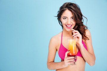 Wall Mural - Portrait of a pretty young brunette girl drinking cocktail